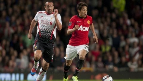 Manchester United's Shinji Kagawa, right, keeps the ball from Liverpool's Jose Enrique during their English League Cup soccer match at Old Trafford Stadium, Manchester, England, Wednesday Sept. 25, 2013. (AP Photo/Jon Super)