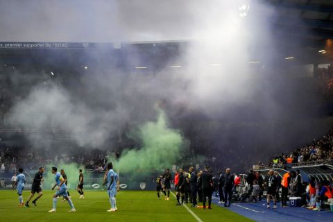 Fans burn flare during the French League One soccer match between Troyes and Paris Saint Germain, at the Stade de l'Aube, in Troyes, France, Sunday, May 7, 2023. (AP Photo/Lewis Joly)