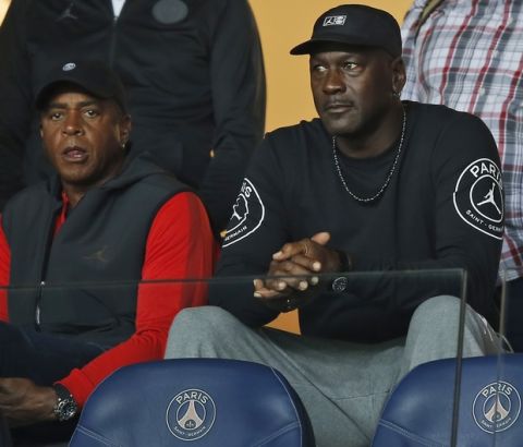 American former professional basketball player Michael Jordan, center, watches the French League One soccer match between Paris-Saint-Germain and Reims at the Parc des Princes stadium in Paris, France, Wednesday, Sept. 26, 2018. (AP Photo/Michel Euler)