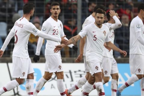 Portugal's Bruno Fernandes, left, celebrates with his teammates after he scored his side's first goal during the Euro 2020 group B qualifying soccer match between Luxembourg and Portugal at the Josy Barthel stadium in Luxembourg, Sunday, Nov. 17, 2019. (AP Photo/Francisco Seco)