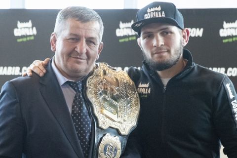 UFC lightweight champion Khabib Nurmagomedov, right, and his father Abdulmanap Nurmagomedov pose with the trophy belt during a news conference in Moscow, Russia, Monday, Nov. 26, 2018. The Russian professional mixed martial arts fighter Nurmagomedov, said he can imagine a reconciliation with Conor McGregor after the bitter feud around last month's title fight, but said he would like to fight Floyd Mayweather Jr.  (AP Photo/Pavel Golovkin)
