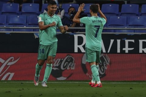 Real Madrid's Casemiro, left, is congratulated by Real Madrid's Eden Hazard after scoring the opening goal during the Spanish La Liga soccer match between RCD Espanyol and Real Madrid at the Cornella-El Prat stadium in Barcelona, Spain, Sunday, June 28, 2020. (AP Photo/Joan Monfort)