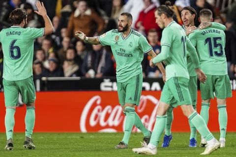 Real Madrid players celebrate the goal of their goalkeeper Thibaut Courtois during the Spanish La Liga soccer match between Valencia and Real Madrid at the Mestalla Stadium in Valencia, Spain, Sunday, December 15, 2019. (AP Photo/Alberto Saiz)