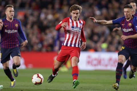 Atletico forward Antoine Griezmann, center, vies for the ball with Barcelona midfielder Arthur, left, and Barcelona defender Clement Lenglet, right, during a Spanish La Liga soccer match between FC Barcelona and Atletico Madrid at the Camp Nou stadium in Barcelona, Spain, Saturday April 6, 2019. (AP Photo/Manu Fernandez)