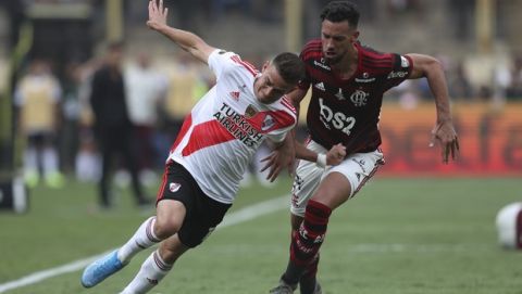Rafael Borre of Argentina's River Plate, left, fights for the ball with Pablo Mari of Brazil's Flamengo during the Copa Libertadores final soccer match at the Monumental stadium in Lima, Peru, Saturday, Nov. 23, 2019. (AP Photo/Martin Mejia)
