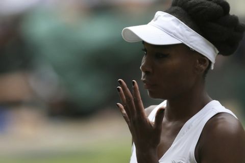 Venus Williams of the United States gestures for a towel to wipe her face as she plays Britain's Johanna Konta during their Women's Singles semifinal match on day nine at the Wimbledon Tennis Championships in London Thursday, July 13, 2017. (AP Photo/Tim Ireland)