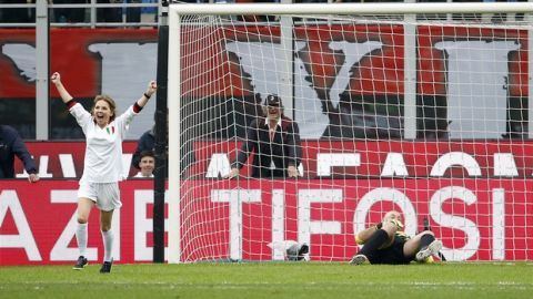 Geri Halliwell, left, celebrates after kicking a penalty kick against former Liverpool goalkeeper Bruce Grobbelaar prior to the Serie A soccer match between AC Milan and Napoli at the San Siro stadium in Milan, Italy, Sunday, April 15, 2018. (AP Photo/Antonio Calanni)