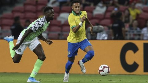 Brazil's Neymar Jr, right, and Nigeria's Anderson Esiti go for the ball during the international friendly match between Brazil and Nigeria in Singapore, Sunday, Oct. 13, 2019. (AP Photo/Danial Hakim)