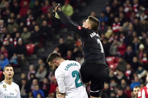 FILE - In this Saturday, Dec. 2, 2017 file photo, Athletic Bilbao's goalkeeper Kepa Arrizabalaga, top, pushes the ball beside Real Madrid's Daniel Carvajal during their Spanish La Liga soccer match at San Mames stadium, in Bilbao, northern Spain. Athletic Bilbao has said on Monday, Jan. 22, 2018 it has extended the contract of young goalkeeper Kepa Arrizabalaga until June 2025, ending speculation about his move to Real Madrid. The 23-year-old Kepa admitted he had offers to leave Athletic, but decided to stay at the club he considers his home. (AP Photo/Alvaro Barrientos, file)