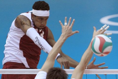 Venezuela's Ivan Marquez, left, spikes the ball against Mexico's Gustavo Meyer during a men's volleyball match at the Pan American Games in Guadalajara, Mexico, Monday, Oct. 24, 2011. (AP Photo/Martin Mejia)