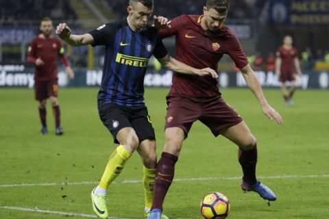 Inter Milan's Ivan Perisic, left, and Roma's Edin Dzeko vie for the ball during an Italian Serie A soccer match between Inter Milan and Roma, at the San Siro stadium in Milan, Italy, Sunday, Feb. 26, 2017. (AP Photo/Luca Bruno)