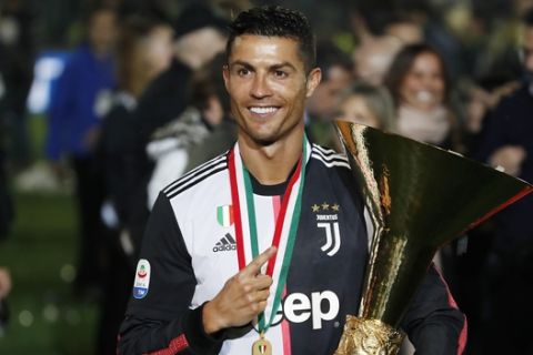 Juventus' Cristiano Ronaldo holds up the Serie A soccer title trophy, at the Allianz Stadium, in Turin, Italy, Wednesday, April 3, 2019. (AP Photo/Antonio Calanni)