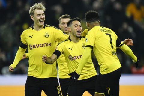 Dortmund's Raphael Guerreiro, center, celebrates after he scored the opening goal in the first minute during the German Bundesliga soccer match between Borussia Dortmund and 1. FC Cologne in Dortmund, Germany, Friday, Jan. 24, 2020. (AP Photo/Martin Meissner)