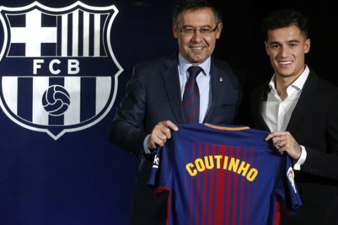 Barcelona's new signing Brazilian Philippe Coutinho, right, and FC Barcelona's president Josep Maria Bartomeu pose for the media, during his official presentation at the Camp Nou stadium in Barcelona, Spain, Monday, Jan. 8, 2018. Coutinho is joining Barcelona after Liverpool agreed Saturday to sell the Brazilian in a deal that makes him one of the most expensive players in soccer history. (AP Photo/Manu Fernandez)