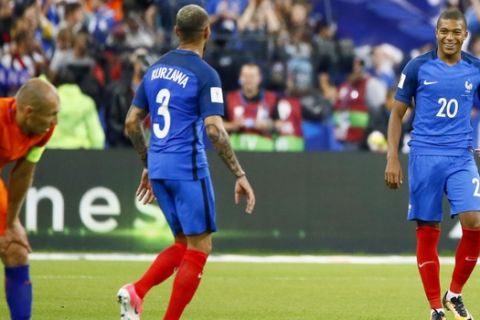 France's Kylian Mbappe, right, and France's Layvin Kurzawa reacts while Netherlands' Arjen Robben, 2nd left, looks on at the end of the World Cup Group A qualifying soccer match between France and The Netherlands at the Stade de France stadium in Saint-Denis, outside Paris, Thursday, Aug.31, 2017. (AP Photo/Francois Mori)