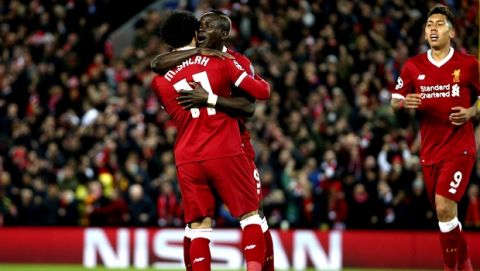 Liverpool's Sadio Mane celebrates with Mohamed Salah, left, and Roberto Firmino, right, after scoring his side's third goal during the Champions League semifinal, first leg, soccer match between Liverpool and AS Roma at Anfield Stadium, Liverpool, England, Tuesday, April 24, 2018. (AP Photo/Dave Thompson)