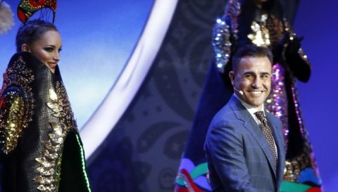 Former Italian soccer international Fabio Cannavaro smiles as he walks on stage to assist with the 2018 soccer World Cup draw in the Kremlin in Moscow, Friday Dec. 1, 2017. (AP Photo/Pavel Golovkin)