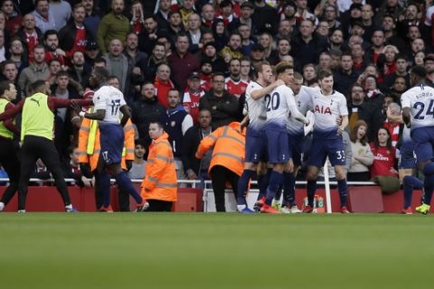 Tottenham's Harry Kane, center, celebrates with his teammates after scoring his side's opening goal from the penalty spot as Tottenham's Moussa Sissoko, third left, agrees with Arsenal's Stephan Lichtsteiner, left, during the English Premier League soccer match between Arsenal and Tottenham Hotspur at the Emirates Stadium in London, Sunday Dec. 2, 2018. (AP Photo/Tim Ireland)