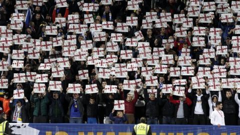 Fans hold up placards with the English flags before the Euro 2020 group A qualifying soccer match between Kosovo and England at Fadil Vokrri stadium in Pristina, Kosovo, Sunday, Nov. 17, 2019. (AP Photo/Boris Grdanoski)