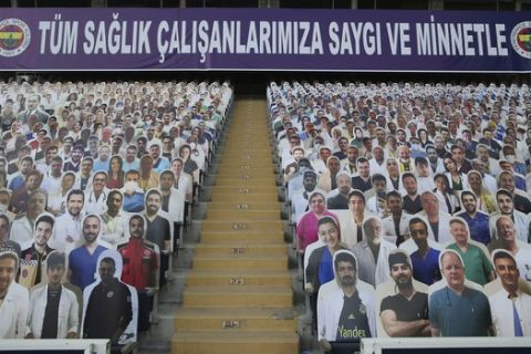A view of cardboards with photographs of medical staff on the stands prior to a Turkish Super League soccer match between Fenerbahce and Kayserispor in Istanbul, Friday, June 12, 2020. The banner reads in Turkish: 'To all our medical staff with respect and gratefulness'. The Turkish Super Lig resumed its season on Friday without spectators after it had suspended games since March 20 due to the coronavirus pandemic, later than many other European leagues. (Erdem Sahin/Pool via AP)