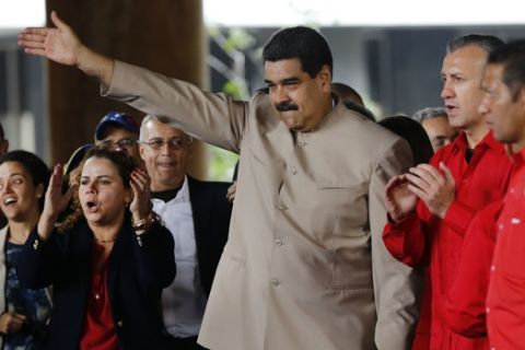 Venezuela's President Nicolas Maduro waves to supporters outside the National Electoral Council headquarters (CNE) in Caracas, Venezuela, Wednesday, May 3, 2017. Maduro delivered a decree kicking off a process to rewrite the troubled nations constitution. (AP Photo/Ariana Cubillos)