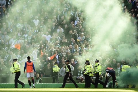 Flares on the pitch after the first Celtic goal against Rangers Jermain Defoe, during their Scottish Premiership soccer match at Celtic Park in Glasgow, Scotland, Sunday March 31, 2019. (Ian Rutherford/PA via AP)