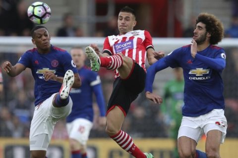 Southampton's Dusan Tadic, centre, in action against Manchester United's Marouane Fellaini, right, and Anthony Martial during an English Premier League soccer match at St Mary's, Southampton, England, Wednesday, May 17, 2017. (Andrew Matthews/PA via AP)