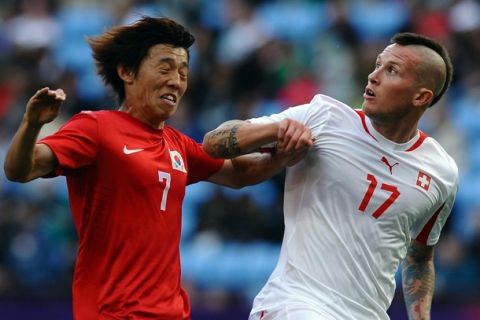 Korea's Bokyung Kim (L) challenges Switzerland's Michel Morganella (R) during the London 2012 Olympic men's football match between South Korea and Switzerland at The City of Coventry Stadium in Coventry, central England, on July 29, 2012. AFP PHOTO/PAUL ELLIS        (Photo credit should read PAUL ELLIS/AFP/GettyImages)