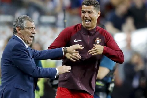 Portugal's Cristiano Ronaldo and Portugal coach Fernando Santos react moments before the end of the Euro 2016 final soccer match between Portugal and France at the Stade de France in Saint-Denis, north of Paris, Sunday, July 10, 2016. Portugal won 1-0. (AP Photo/Frank Augstein)