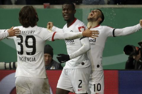 Frankfurt's Filip Kostic, right, celebrates after scoring his side's third goal with Frankfurt's Evan N'Dicka, center and Frankfurt's Goncalo Paciencia, left, during the German DFB Cup third round match between Eintracht Frankfurt and RB Leipzig at the Commerzbank-Arena stadium in Frankfurt, Germany, Tuesday, Feb. 4, 2020. (AP Photo/Michael Probst)
