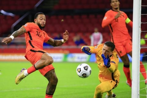 Netherlands' Memphis Depay, left, kicks at the ball as Poland's goalkeeper Wojciech Szczesny reaches out to block the shot during the UEFA Nations League soccer match between the Netherlands and Poland in the Johan Cruyff ArenA in Amsterdam, Netherlands, Friday, Sept. 4, 2020. (AP Photo/Peter Dejong)