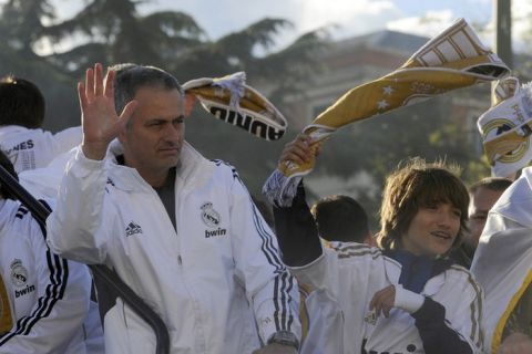 Real Madrid's Portuguese coach Jose Mourinho (L) celebrates on an open bus at Cibeles square in Madrid on May 3, 2012, a day after winning the Spanish league title for the first time since 2008.  Real Madrid's 3-0 away win over Athletic Bilbao sealed the league, putting them seven points clear of last year's winners and arch rivals Barcelona with just two games to go and delivering the team's 32nd league crown.  AFP PHOTO / PIERRE-PHILIPPE MARCOUPIERRE-PHILIPPE MARCOU/AFP/GettyImages