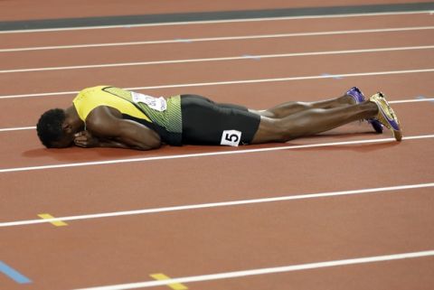 Jamaica's Usain Bolt lies on the track after suffering an injury in the men's 4x100-meter final during the World Athletics Championships in London Saturday, Aug. 12, 2017. (AP Photo/Matthias Schrader)