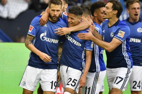 Schalke's Guido Burgstaller, left, is celebrated by teammates after scoring during the German Bundesliga soccer match between FC Schalke 04 and VFB Stuttgart at the Arena in Gelsenkirchen, Germany, Sunday, Sept. 10, 2017. (AP Photo/Martin Meissner)
