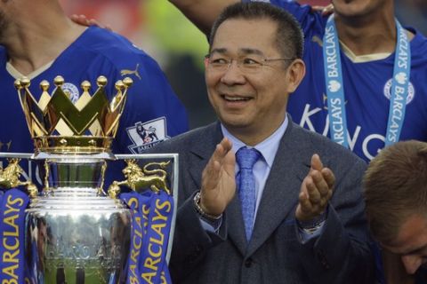 FIEL - In this May 7, 2016, file photo, Vichai Srivaddhanaprabha applauds beside the trophy as Leicester City celebrate becoming the English Premier League soccer champions at King Power stadium in Leicester, England. Thai billionaire and Leicester City owner Srivaddhanaprabha, who died when his helicopter crashed in a parking lot next to the soccer club's stadium, was known to fans as a smiling, benevolent man who gave away free beers and hot dogs on his birthday and brought the club its fairytale English Premier League title in 2016. He was 60. (AP Photo/Matt Dunham, File)