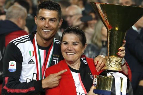 Juventus' Cristiano Ronaldo poses with his mother Dolores Aveiro, right, after winning the Serie A soccer title trophy, at the Allianz Stadium, in Turin, Italy, Sunday, May 19, 2019. (AP Photo/Antonio Calanni)