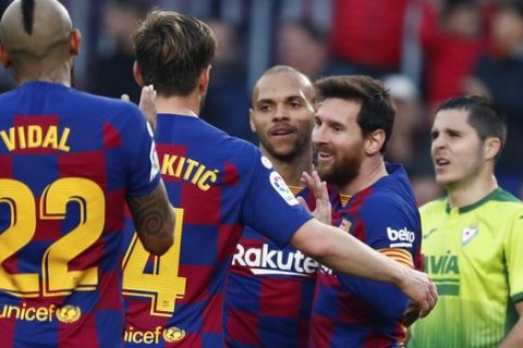 Barcelona's Lionel Messi, 4th from left, celebrates with team mates after scoring his side's fourth goal during a Spanish La Liga soccer match between Barcelona and Eibar at the Camp Nou stadium in Barcelona, Spain, Saturday Feb. 22, 2020. (AP Photo/Joan Monfort)