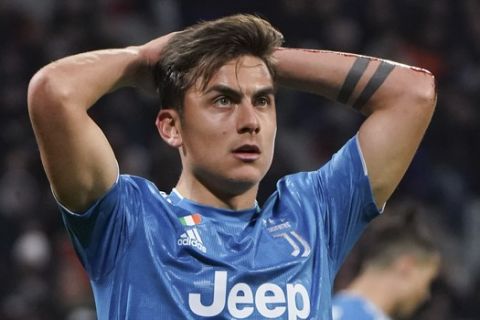 Juventus' Paulo Dybala reacts after missing a chance to score during a round of sixteen, first leg, soccer match between Lyon and Juventus at the at the Lyon Olympic Stadium in Decines, outside Lyon, France, Wednesday, Feb. 26, 2020. (AP Photo/Laurent Cipriani)