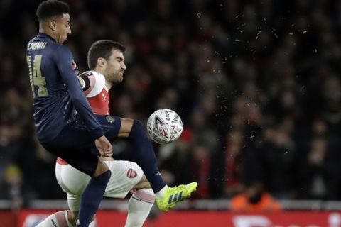Arsenal's Sokratis Papastathopoulos, right, duels for the ball with Manchester United's Jesse Lingard during the English FA Cup fourth round soccer match between Arsenal and Manchester United at the Emirates stadium in London, Friday, Jan. 25, 2019. (AP Photo/Matt Dunham)