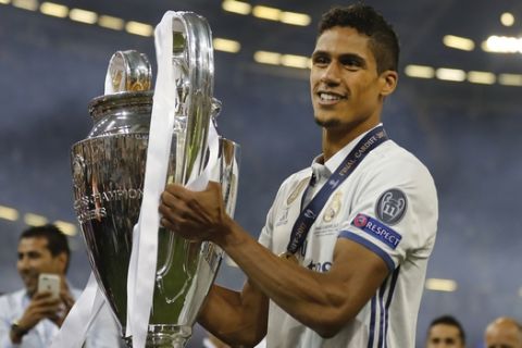 Real Madrid's Raphael Varane celebrates with the trophy at the end of the Champions League soccer final between Juventus and Real Madrid at the Millennium Stadium in Cardiff, Wales, Saturday, June 3, 2017. Real won the match 4-1. (AP Photo/Frank Augstein)
