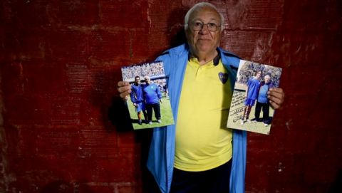 In this Nov. 11, 2016 photo, Ramon Maddoni, head scout at youth soccer academy Club Social Parque and at the Boca Juniors club children's division, poses with photos of himself with professional players Carlos Tevez and Fernando Gago in Buenos Aires, Argentina. Maddoni recalls how he promised Tevez that he'd be a world-class striker long before he became a top goal scorer for clubs in England and Italy. (AP Photo/Natacha Pisarenko)