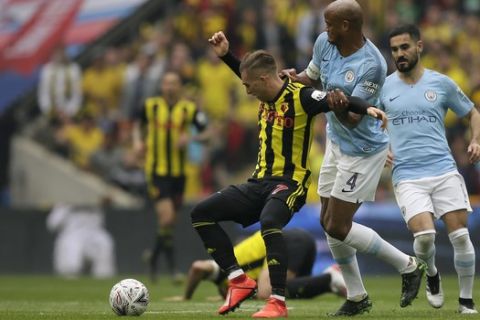 Watford's Gerard Deulofeu, left, fights for the ball with Manchester City's Vincent Kompany during the English FA Cup Final soccer match between Manchester City and Watford at Wembley stadium in London, Saturday, May 18, 2019. (AP Photo/Tim Ireland)