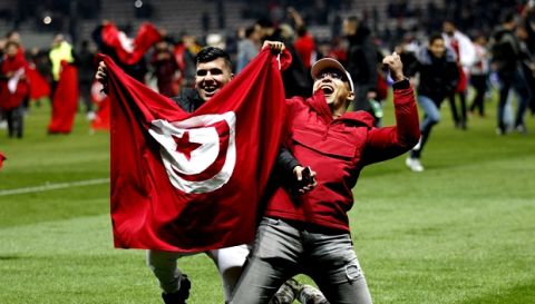 Tunisian supporters pose with the Tunisian flag on the pitch after a friendly soccer match between Tunisia and Costa Rica at the Allianz Riviera stadium in Nice, southern France, Tuesday, March 27, 2018. Tunisia won 1-0. (AP Photo/Claude Paris)