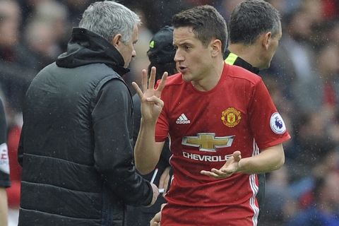 Manchester United's team manager Jose Mourinho, left, and Manchester United's Ander Herrera gesture during the English Premier League soccer match between Manchester United and Chelsea at Old Trafford stadium in Manchester, Sunday, April 16, 2017.(AP Photo/ Rui Vieira)