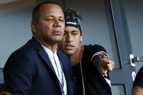 Paris Saint-Germain's, Brazilian soccer star Neymar, right, flanked by his father Neymar Santos, left, watches the match at the Parc des Princes stadium in Paris, Saturday, Aug. 5, 2017, after his official presentation to fans ahead of Paris Saint-Germain's season opening match against Amiens. Neymar would not play in the club's season opener as the French football league did not receive the player's international transfer certificate before Friday's night deadline. The Brazil star became the most expensive player in soccer history after completing his blockbuster transfer from Barcelona for 222 million euros ($262 million) on Thursday. (AP Photo/Francois Mori)