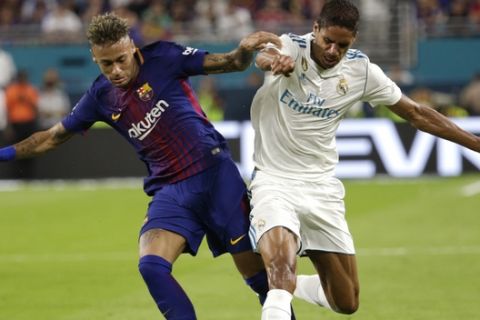Barcelona's Neymar, left, and Real Madrid's Raphael Varane, right, go for the ball during the first half of an International Champions Cup soccer match, Saturday, July 29, 2017, in Miami Gardens, Fla. (AP Photo/Lynne Sladky)