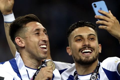 Porto's Hector Herrera, left, and Alex Telles celebrate with their medals at the end of the Portuguese league soccer match between FC Porto and Feirense at the Dragao stadium in Porto, Portugal, Sunday, May 6, 2018. Porto clinched the league title Saturday night, two rounds before the end, when Benfica and Sporting CP tied 0-0 in their Lisbon derby. (AP Photo/Luis Vieira)