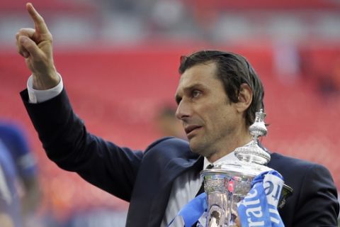 FILE - In this Saturday, May 19, 2018 file photo, Chelsea head coach Antonio Conte holds the trophy after winning the English FA Cup final soccer match against Manchester United at Wembley stadium in London. Chelsea has fired manager Antonio Conte after a two-year tenure in which he won the English Premier League and FA Cup. The London club said on Friday, July 13, "We wish Antonio every success in his future career." (AP Photo/Tim Ireland, file