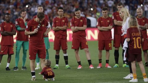 Roma's Francesco Totti looks down to his younger daughter Isabel, while his teammates and his wife Ilary and other daughter Chanel, right, look on as he addresses his fans after an Italian Serie A soccer match between Roma and Genoa at the Olympic stadium in Rome, Sunday, May 28, 2017. Francesco Totti played his final match with Roma against Genoa after a 25-season career with his hometown club. (AP Photo/Alessandra Tarantino) an Italian Serie A soccer match between Roma and Genoa at the Olympic stadium in Rome, Sunday, May 28, 2017. Francesco Totti is playing his final match with Roma against Genoa after a 25-season career with his hometown club. (AP Photo/Alessandra Tarantino)