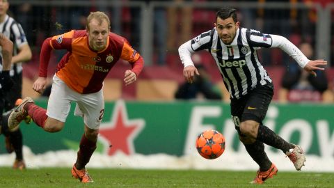 Galatasaray's Semih Kaya (L) fights for the ball with Juventus' Carlos Tevez (R) during their UEFA Champions League group B football match on December 11, 2013, at Turk Telekom Arena in Istanbul. AFP PHOTO/BULENT KILIC        (Photo credit should read BULENT KILIC/AFP/Getty Images)